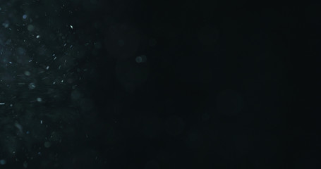 natural dust particles flow in air on black background