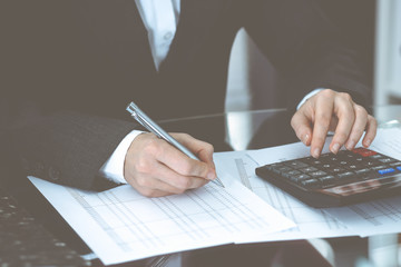 Bookkeeper woman or financial inspector making report, calculating or checking balance, close-up....