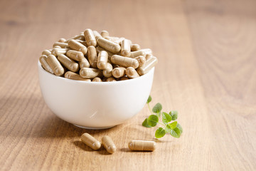 herbal pills on wooden background