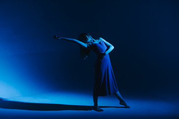 Young stylish girl dancing in the Studio on a colored neon background. Classic dancer.