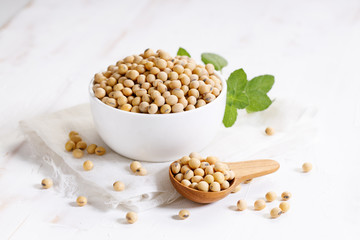 Closeup soy beans in ceramic bowl on white wooden table