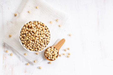 Closeup soy beans in ceramic bowl on white wooden table