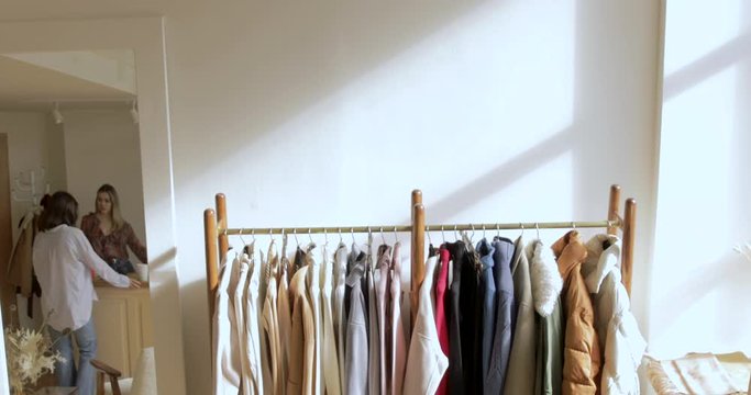 Wooden Hangers With Clothes On Rack. Customer Buying Clothes In Reflection