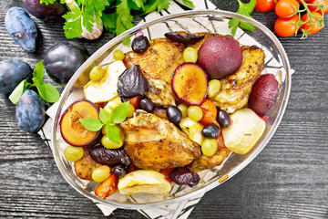 Chicken with fruits and tomatoes in glass pan on board top