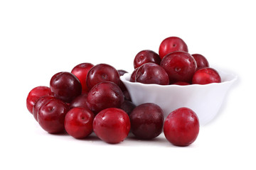 Red plums, dish and leaves