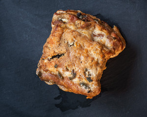 Baked homemade pork ham, a large piece on a slate board close-up