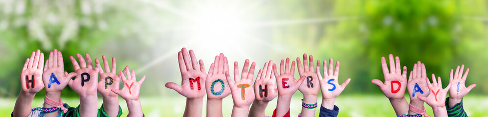 Children Hands Building Colorful English Word Happy Mothers Day. Sunny Green Grass Meadow As Background