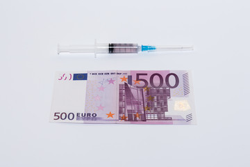 Syringe vaccine and euro bills. Expensive medicine concept.