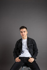Fototapeta premium Young serious man posing in studio. Gray background