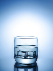 Ice cubes splashing into glass of water