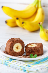 Delicious healthy homemade dessert of bananas, chocolate and cream cheese or ricotta. Banana rolls on a white plate. Treats for kids. Selective focus