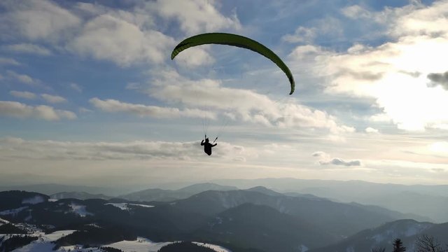 Free flight on paragliding wing in winter mountains, Freedom adventure