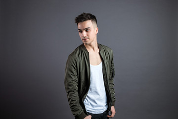 Fototapeta premium Young serious man posing in studio. Gray background