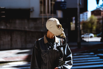 unrecognizable person in a city. He is wearing a gas mask. fear of contagion. global pandemic....