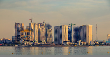 Naklejka premium Colorful Tehran skyline with beautiful Chitgar lake at foreground with amazing reflections from sky at the sunset.