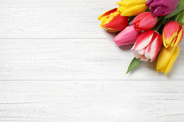 Beautiful spring tulips on white wooden table, flat lay. Space for text