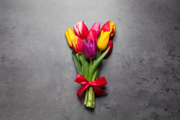 Beautiful spring tulips on grey stone table, top view