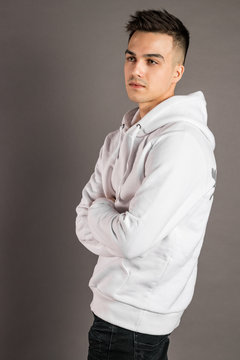 Young serious man posing in studio. Gray background