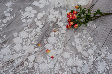 White wooden background with white spring flowers roses and lace ribbon. Happy womans day. The...