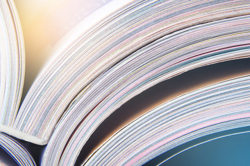 Colorful pages of an open magazine, close up. Selective focus, macro.