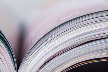 Colorful pages of an open magazine, close up. Selective focus, macro.