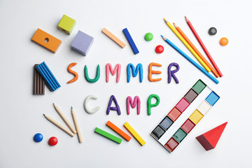 Flat lay composition with phrase SUMMER CAMP made of colorful clay on white background