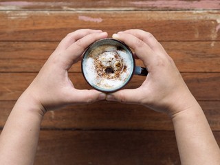 hand holding a cup of hot chocolate with marshmallow grill