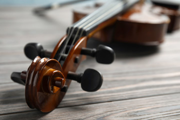 Classic violin on wooden background, closeup view