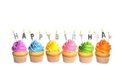 Birthday cupcakes with burning candles on white background