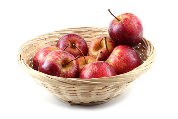 Red little apples on wicker plate