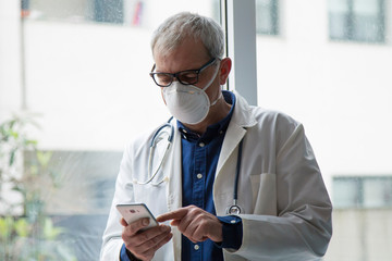 doctor with mask using mobile phone
