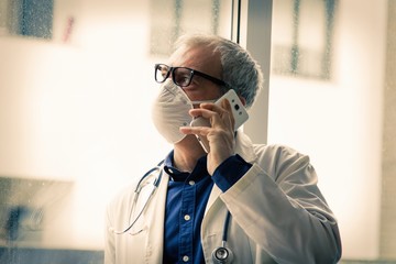 doctor with mask using mobile phone