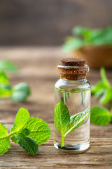 Natural essential oil and mint on a wooden background