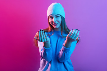 Image of delighted good looking attractive young female raising both hands, smiling sincerely,...