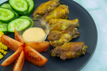 Chicken wings with vegetables and spicy sauce