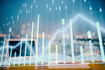 Forex graph hologram on table with computer background. Double exposure. Concept of financial...