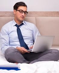 Businessman working in the bed at home