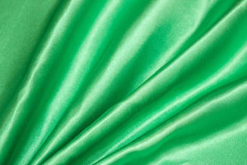 Smooth elegant green silk or satin luxury cloth texture can be used as an abstract background. Crumpled fabric.