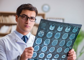 Young doctor looking at computed tomography x-ray image