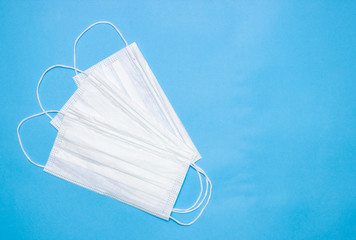 Disposable medical mask on a blue background.