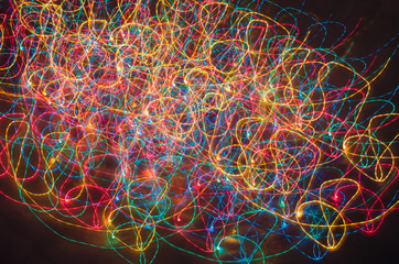 Abstract colorful background with freeze light. Christmas lights draw long curved lines