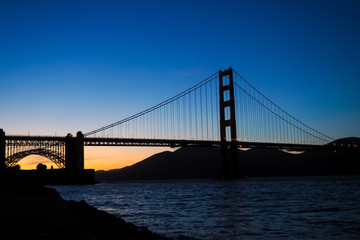 View onto the Golden Gate Bridge in San Francisco at sunset. It connects Peninsula and Marin Headlands. The San Francisco Bay is located on the eastern side of it.