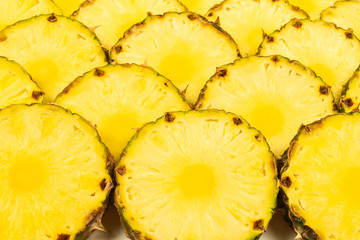 Pineapple juicy yellow slices background. Top view.