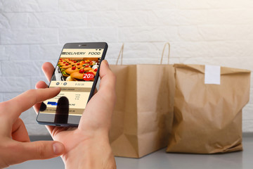 man holding phone with app delivery food screen