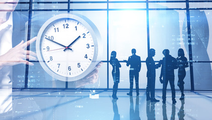 Business people with clock in office