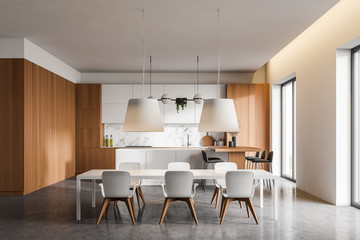 White and wooden kitchen with table and bar