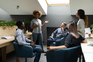 Confident African American businesswoman holding briefing with diverse colleagues, team leader...