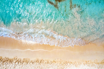 Fototapeta na wymiar Top view aerial drone photo of ocean seashore with beautiful turquoise water and sea waves. Caribbean resort. Vacation travel background.