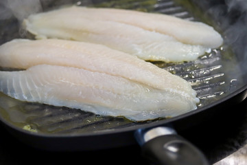 filet de tilapia en train de cuire dans une poêle