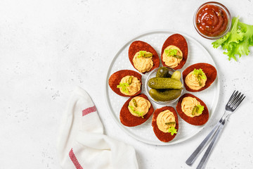 Fototapeta na wymiar Easter appetizer, bloody mary deviled eggs with pickles and bbq sauce. Top view, copy space.